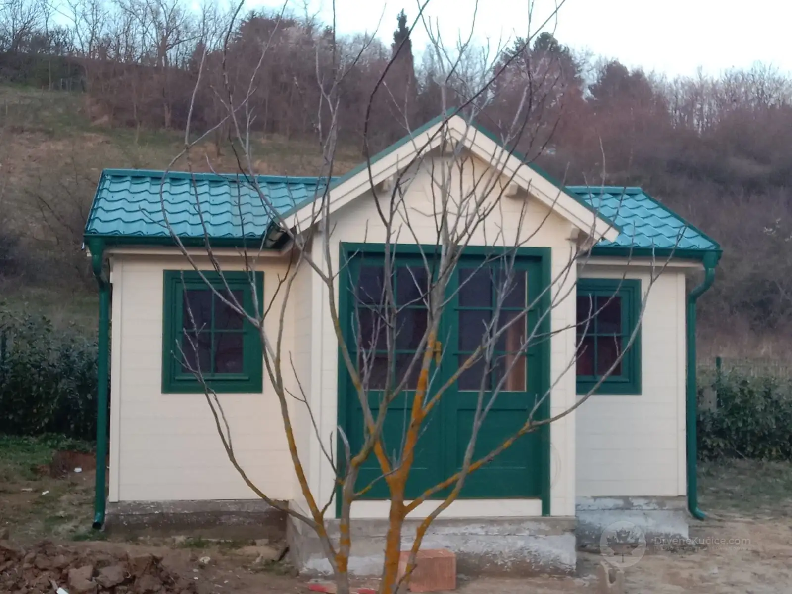 Drvena kućica u obliku slova L sa zelenim vratima, fotografija 2